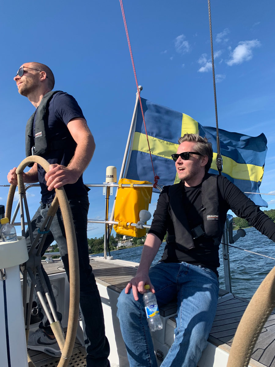 Två personer på en segelbåt med vind i en flagga